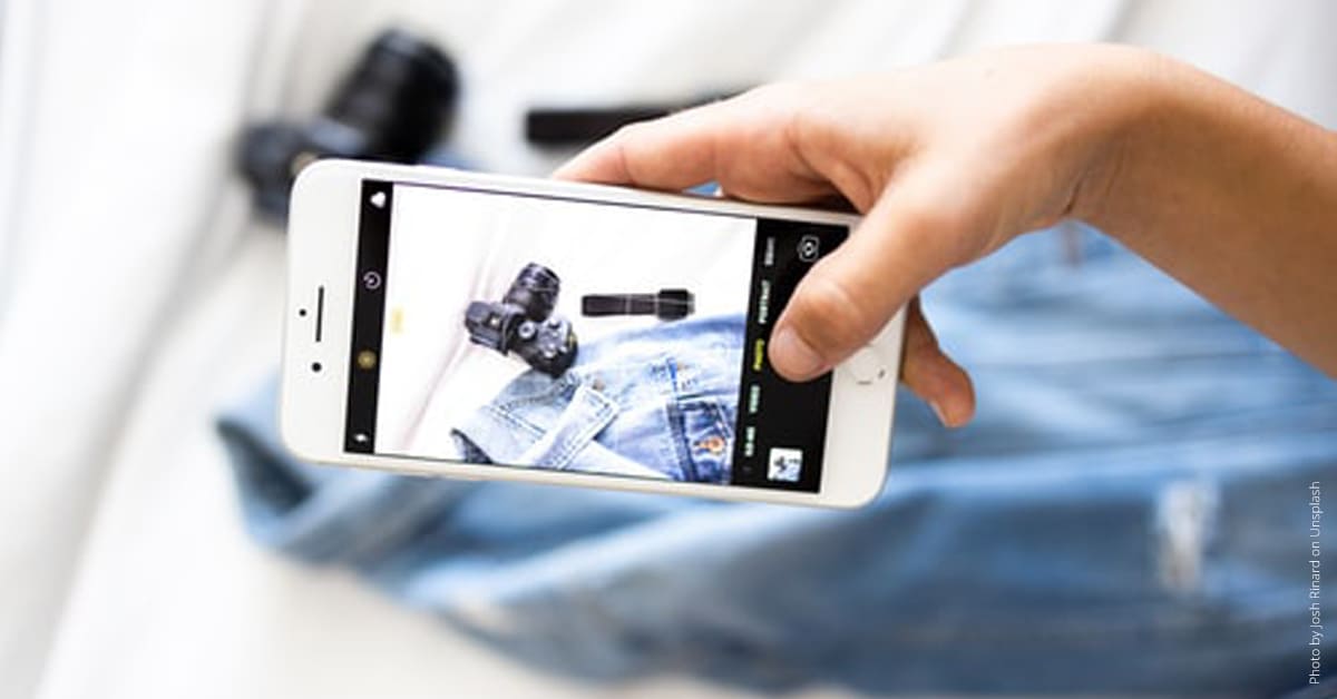 Smartphone fotografiert Jeans und Kamera