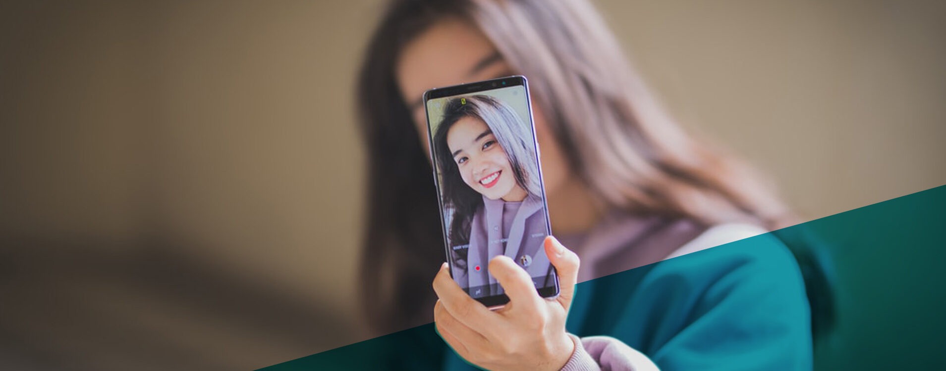 Junge Frau mit braunen Haaren macht Selfie