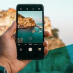 Smartphone in einer Hand macht Foto von einer Landschaft