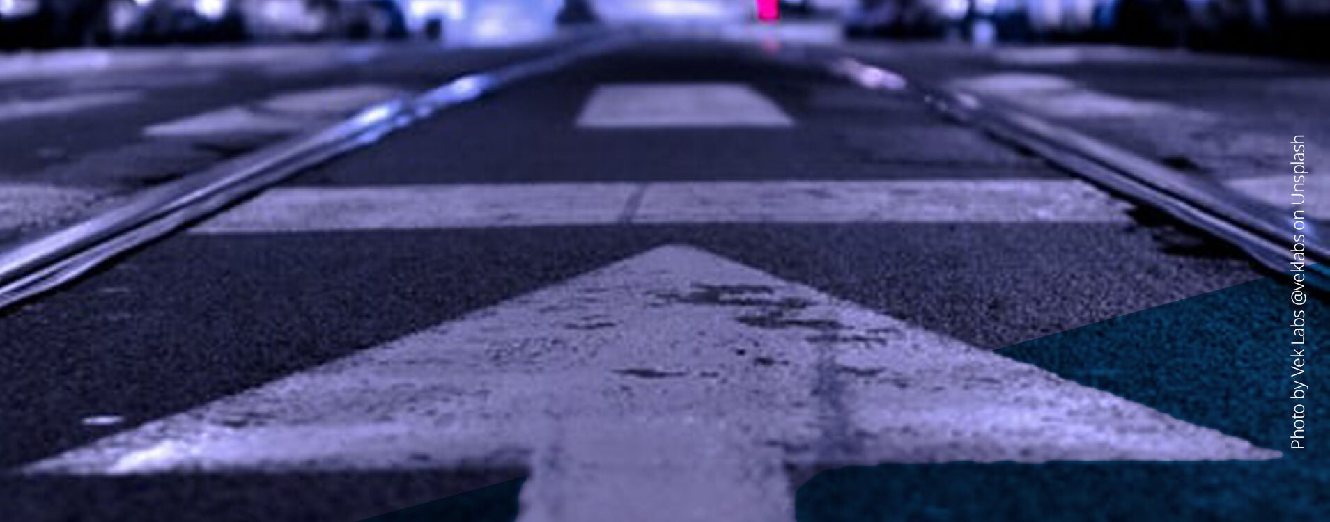 Nächtliche Straße in der Stadt mit einem Pfeil, der auf den Horizont zeigt